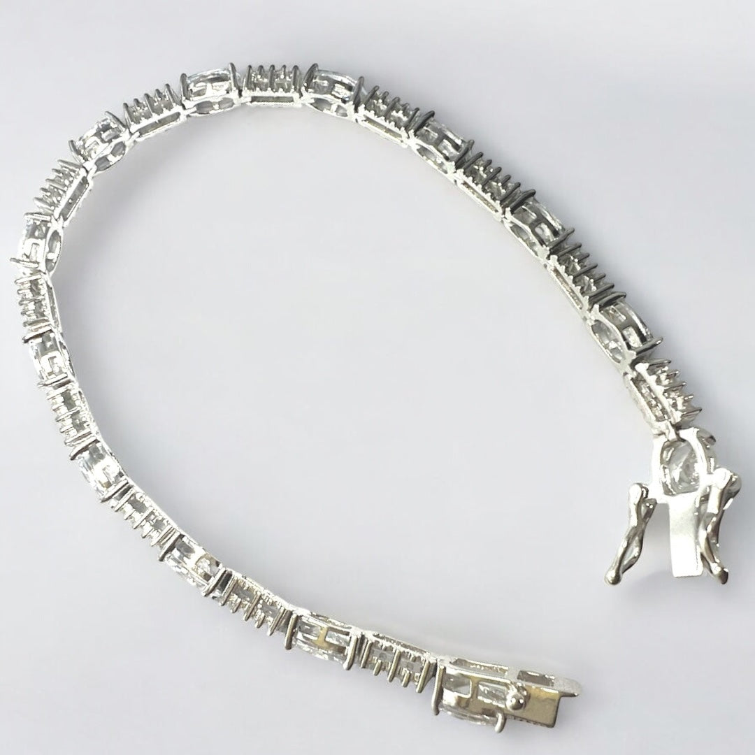 The Zevaayra Victoria Royale Bracelet features silver rectangular links and a box clasp, exemplifying timeless craftsmanship. It’s displayed in a curved shape against a plain white background.