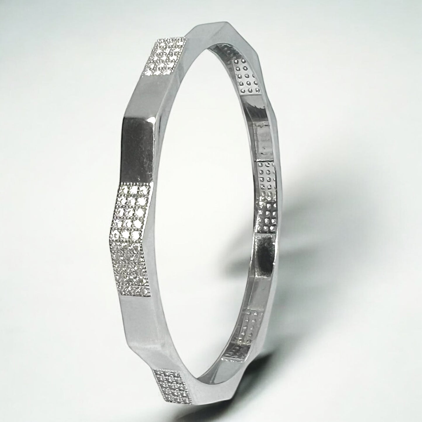 The Zevaayra Zeneer Cuff – Polished Silver Brilliance features an angular, faceted design with sparkling cubic zirconia clusters—an elegant accessory for any occasion.